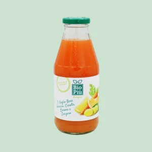 Bottiglietta da 500 ml di succo biologico Bio Più a base di arancia, carota, limone e zenzero, tappo verde e contenuto arancio vivo su sfondo verde chiaro.