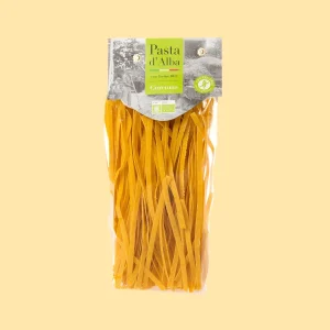 Confezione da 250g di tagliatelle biologiche Pasta d’Alba a base di farina di riso e curcuma, in busta trasparente con etichetta verde.