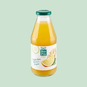 Bottiglia da 220ml in vetro di bevanda biologica Bio Più con succo d’arancia e zenzero , etichetta con fetta di arancia e radice di zenzero su sfondo verde chiaro.