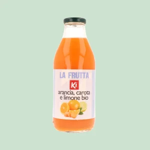 Bottiglia in vetro di succo biologico Ki alla frutta ACE con arancia, carota e limone, vista frontale su sfondo verde chiaro.